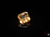 gros plan d'un diamant jaune sur une surface noire