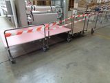a long line of tables in a warehouse with orange and white tape