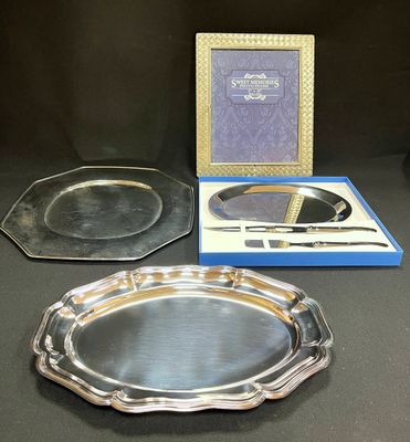 two silver trays and a mirror on a table next to a picture frame