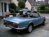 an image of a blue convertible car parked in front of a house
