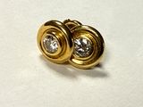 a pair of gold and diamond earrings on top of a piece of paper