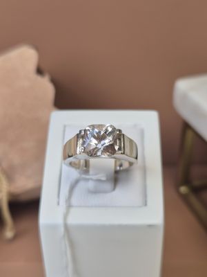 une bague en diamant posée dans une boîte blanche sur une table