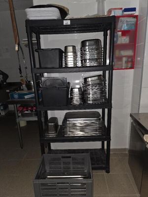 une étagère noire sur laquelle sont posées de nombreuses assiettes et casseroles