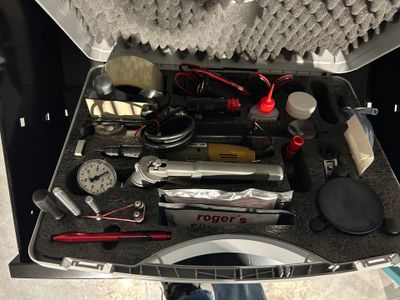 a suitcase filled with tools and other items on the floor