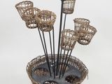 a basket with a bunch of flowers in it on a stand
