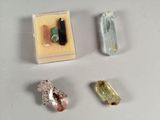 Trois cristaux de couleurs différentes sont posés sur une table, à côté d'une petite boîte.
