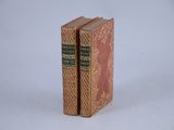 two books sitting on top of each other on a white surface