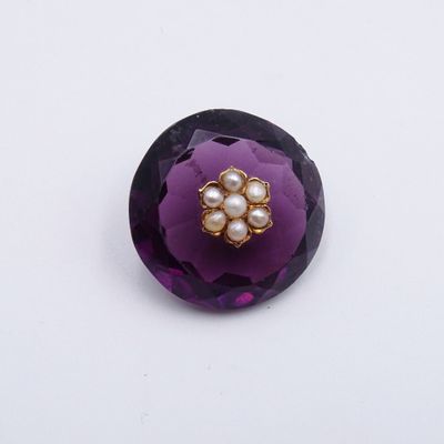 une fleur violette parsemée de perles sur un fond blanc