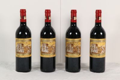 trois bouteilles de vin sont alignées contre un mur blanc