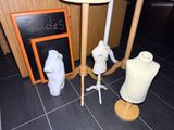 three mannequins, a lamp, and a chalk board on the floor