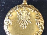a gold pocket watch on a black surface