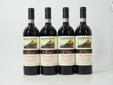quatre bouteilles de vin sont alignées sur une surface blanche