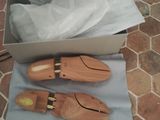 pair of wooden shoes in a box on a tile floor