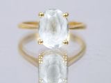 an image of a gold ring with a white topazr stone