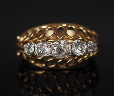 gros plan d'une bague en or et diamants sur une surface noire