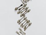 a group of forks and spoons arranged in the shape of a wave