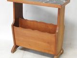 a small wooden magazine rack with a marble top
