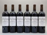 six bouteilles de vin sont alignées sur une table