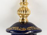 a blue glass bottle with a gold decoration on it