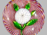 une boule de verre surmontée d'une fleur blanche