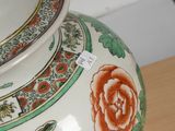 a vase with a rose painted on it sitting on a table