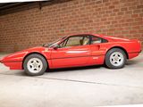 a red sports car parked in front of a brick wall