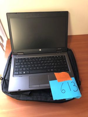 a laptop computer sitting on top of a bag on a desk
