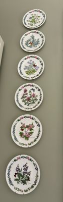 de nombreuses assiettes ornées de fleurs étaient alignées sur une table