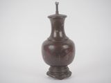 a brown vase that is sitting on a white surface