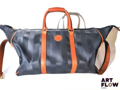 un grand sac bleu avec des anses orange sur fond blanc