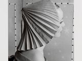 black and white photograph of a woman with a paper hat on her head