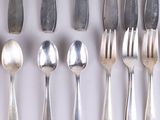a lot of silver spoons and forks on the table