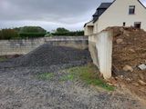 un tas de gravier à côté d'un bâtiment et d'un mur