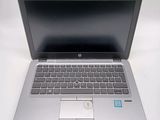 a silver laptop computer sitting on a white surface