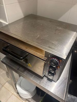 un plan de travail en acier inoxydable sur lequel est installé un four à pizza