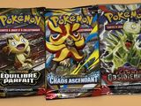 trois paquets de cartes à collectionner Pokémon posés sur une table