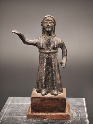 une statue en bronze représentant une femme tendant la main