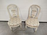 pair of white painted chairs with upholstered seat cushions