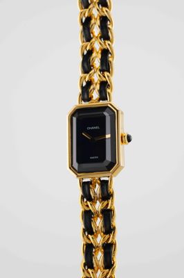 a close up of a watch with a chain around it