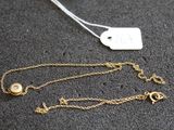 gros plan sur un collier en or portant une étiquette