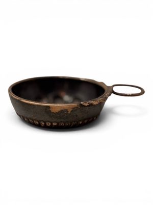 a close up of a metal bowl on a white surface