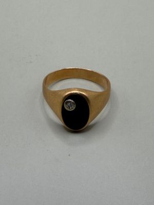 an image of a gold ring with a black stone and a diamond