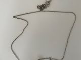 gros plan d'un collier sur une surface blanche avec une étiquette