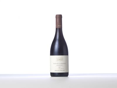 une bouteille de vin rouge posée sur une table blanche