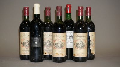 six bouteilles de vin sont alignées sur une table