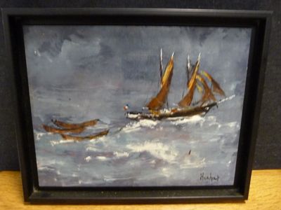tableau à l'huile encadré représentant un voilier sur une mer agitée, posé sur une table en bois