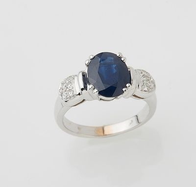a close up of a sapphire and diamond ring on a white background