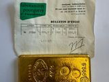 un gros plan d'un morceau d'or posé sur une feuille de papier