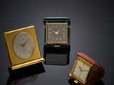 three different clocks sitting on top of a table next to each other