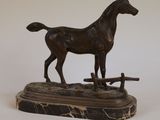 statue en bronze représentant un cheval, posée sur un socle en marbre, sur fond blanc